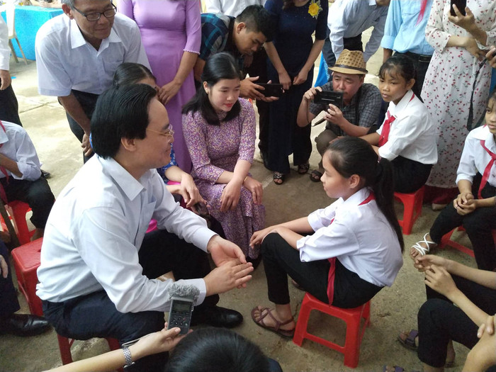 Bộ trưởng Phùng Xuân Nhạ động viên học sinh vùng rốn lũ vượt qua khó khăn để học tốt.