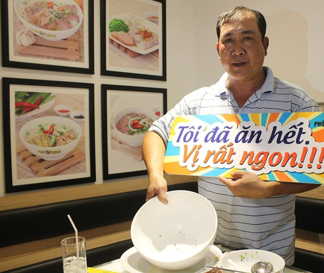 Một khách hàng may mắn dành chiến thắng được nhà hàng đề nghĩ cầm biển chụp hình nhằm PR (ảnh nguồn Tri thức trực tuyến)