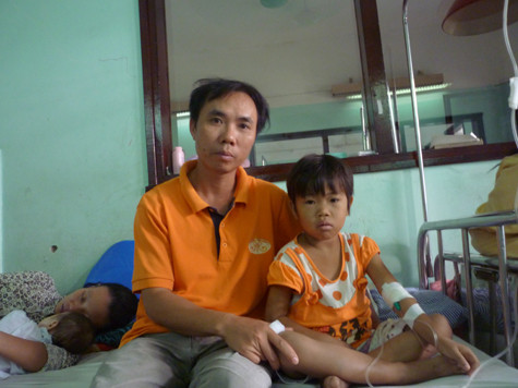 "Còn nước còn tát. Vợ chồng tôi sẽ cố đến khi nào không thể cố được nữa để giành giật cuộc sống cho con", anh Vi Văn Chình bên con gái tại phòng bệnh. (Ảnh Thu Hòe)