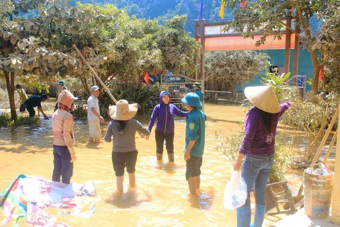 Các thầy cô lội nước lũ dọn trường.