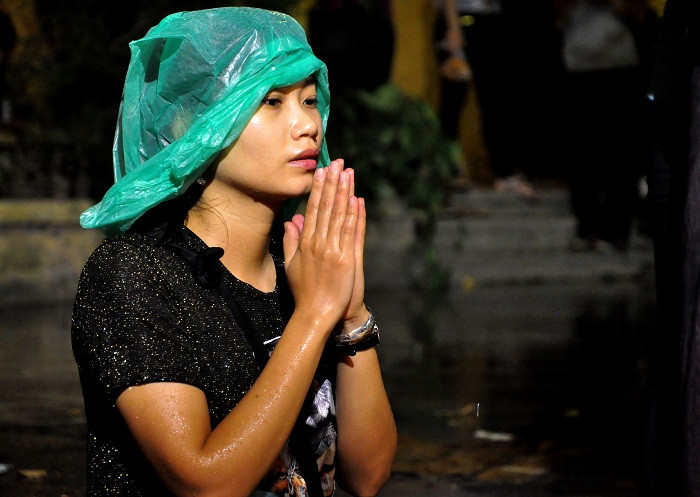 Nhiều người vẫn ngồi dưới mưa, chắp tay cầu khấn làm lễ