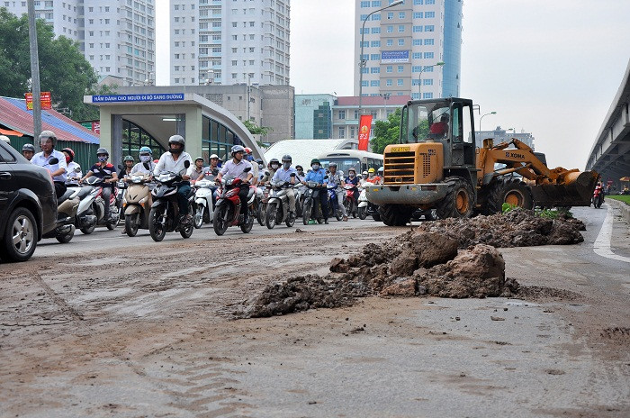 Máy xúc bùn cũng được điều động tới hiện trường để thu gom đất bùn vương vãi