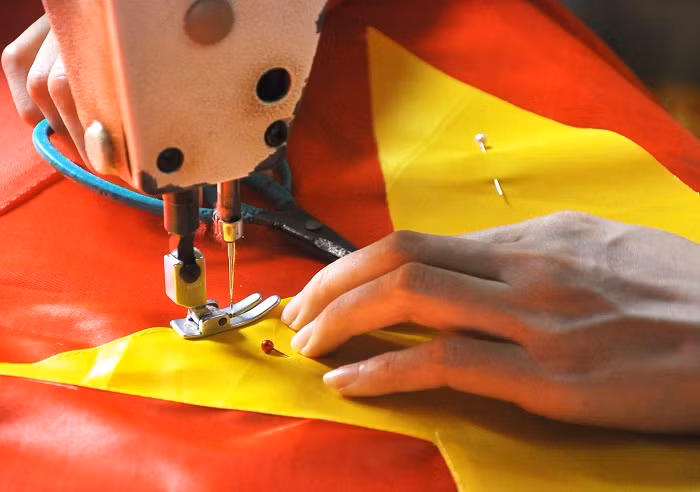 Tỉ mỉ trong từng mũi khâu, đường chỉ để cờ được đẹp và vuông vắn.