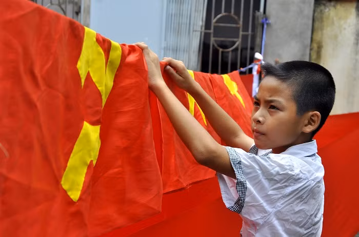 Ngoài giờ đến trường, em Nguyễn Nam – con trai anh Phục thường về phụ giúp bố mẹ với việc phơi cờ, cuộn vải…