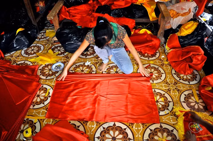 “May cờ Tổ quốc không chỉ đơn giản là chỉ cần may giỏi mà điều quan trọng và quyết định để có lá cờ đẹp chính là từ khâu chọn vải. Khi kéo sợi vải, vải phải thẳng nếu không cờ sẽ bị xoăn” – Chị Đào Thị Duyên vợ anh Phục chia sẻ.