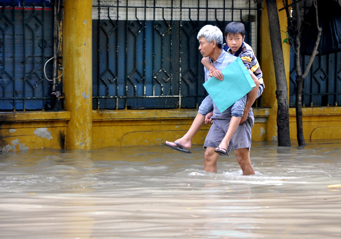 Nước ngập khiến người bệnh và người nhà gặp nhiều bất tiện và khó khăn trong việc đi lại tới bệnh viện