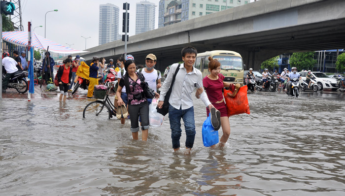 Người đi bộ thì phải lội nước qua các điểm ngập để đến được bến xe