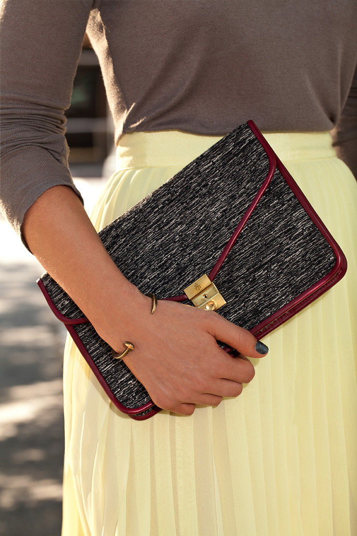 Kết hợp với bộ trang phục này là chiếc túi cầm tay làm từ chất liệu dạ Kết hợp với bộ trang phục này là chiếc túi cầm tay làm từ chất liệu dạ