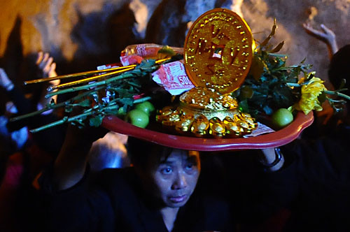 Một người phụ nữ vất vả đội mâm đồ lễ để tìm lối ra. Một người phụ nữ vất vả đội mâm đồ lễ để tìm lối ra.