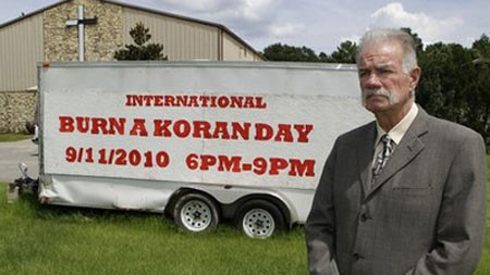 Mục sư Terry Jones tại nhà thờ Dove World Outreach Center bên cạnh tấm biển thông báo thời gian đốt kinh Koran năm 2010 Mục sư Terry Jones tại nhà thờ Dove World Outreach Center bên cạnh tấm biển thông báo thời gian đốt kinh Koran năm 2010
