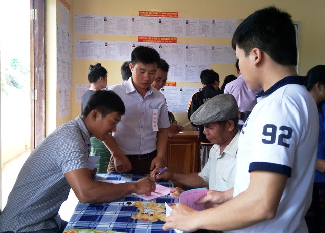 Cán bộ hướng dẫn cho người dân bỏ phiếu (Ảnh: Thủy Phan)