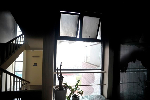 Kính và tường các nhà bên cạnh đều vỡ vụ và cháy đen.