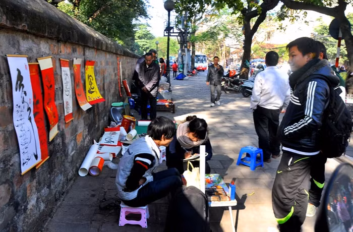 Phía ngoài vỉa hè Văn Miếu vẫn còn đó những ông đồ không có diện tích hoạt động trong “Phố ông Đồ” vẫn vừa bán chữ vừa chạy.