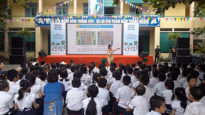 Các bạn học sinh tiểu học được các cô, chú Cảnh sát giao thông phổ biến kiến thức về an toàn giao thông. Ảnh: TT