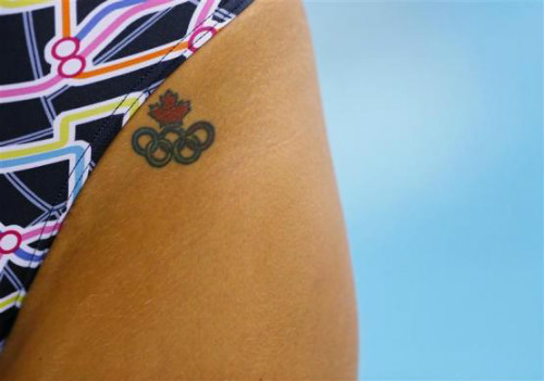Một vận động viên bơi người Canada để lộ hình xăm biểu tượng Olympic, còn phía trên là biểu tượng quốc kỳ Canada. Một vận động viên bơi người Canada để lộ hình xăm biểu tượng Olympic, còn phía trên là biểu tượng quốc kỳ Canada.