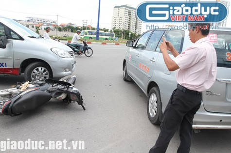 Tài xế taxi đứng chụp ảnh trong khi người bị nạn đang nằm sõng soài dưới đường