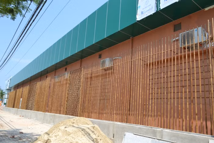 Phía bên ngoài là bức tường bê - tông cao hơn 10 mét, che kín mọi kiến trúc bên trong.