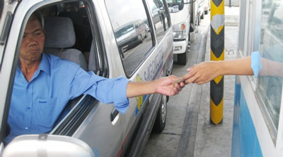 Một tài xế nhăn nhó khi trả tiền thu phí tại trạm thu phí Thân Cửu Nghĩa. Một tài xế nhăn nhó khi trả tiền thu phí tại trạm thu phí Thân Cửu Nghĩa.