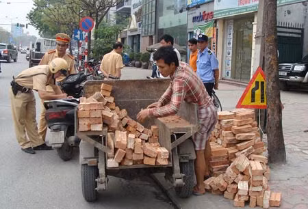Xe ba gác tự chế vi phạm bị lực lượng cảnh sát giao thông Hà Nội lập biên bản xử lý - ảnh nguồn: Báo Công an nhân dân.