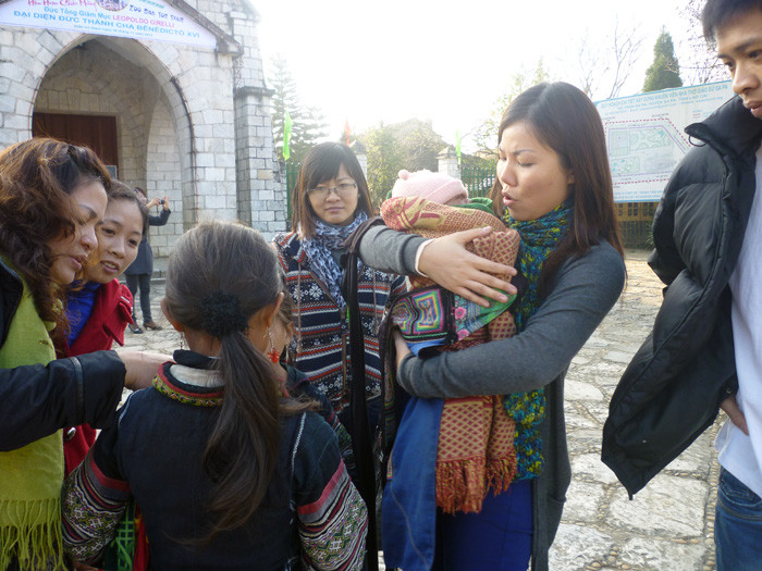 Đứa trẻ này mới chỉ hơn 1 tháng tuổi, đói sữa khóc ngặt trên lưng chị gái khiến khách du lịch không khỏi xót xa