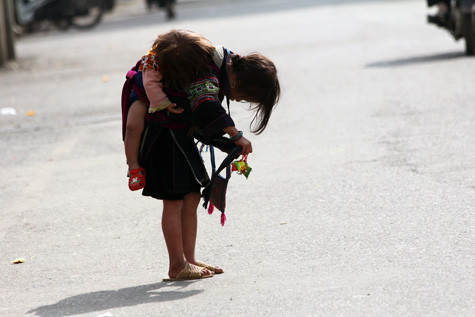 Những tấm lưng nhỏ bé sớm bị "còng" xuống vì "địu em" lang thang ở chợ hết ngày này qua ngày khác