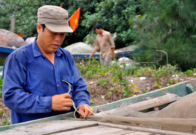 Anh Nguyễn Văn Hiện xã Hải Đông (Hải Hậu, Nam Định) đang nhanh chóng cột lại lưới trên thuyền.
