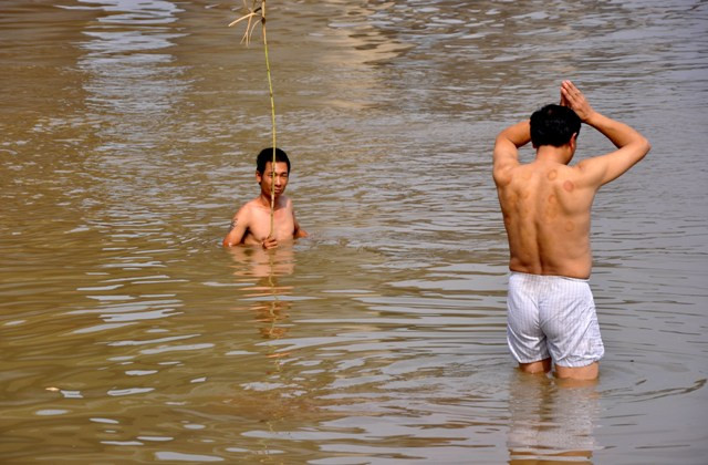 Anh Nguyễn Phúc Kiên (cầm que) đang tìm kiếm xác chị Huyền