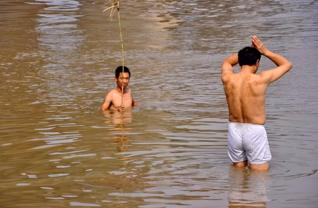 Anh Nguyễn Phúc Kiên (cầm que) đang tìm kiếm xác chị Huyền