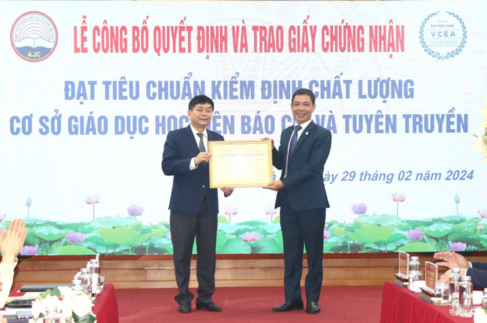 Tiến sĩ Nguyễn Đình Huy, Phó Giám đốc Trung tâm Kiểm định chất lượng giáo dục - Trường Đại học Vinh (bên phải) trao Giấy chứng nhận đạt tiêu chuẩn chất lượng cơ sở giáo dục cho Học viện Báo chí và Tuyên truyền 2.jpg