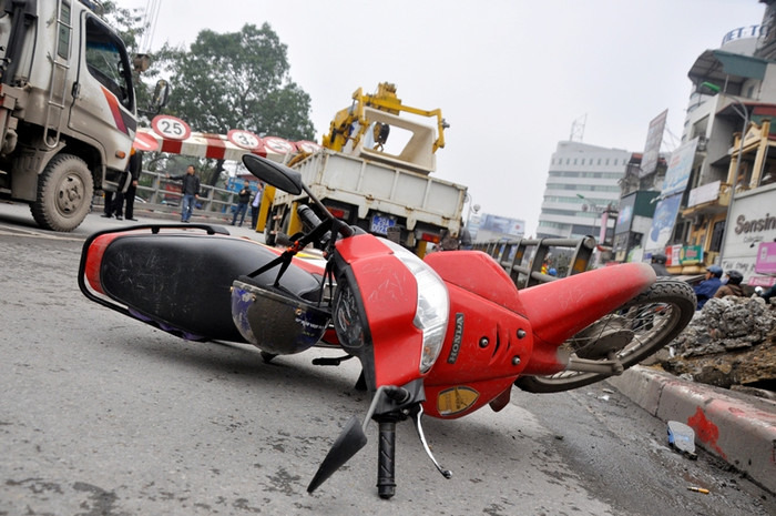 Chiếc xe wave của người phụ nữ bị trôi xuống dưới đuôi xe cẩu.