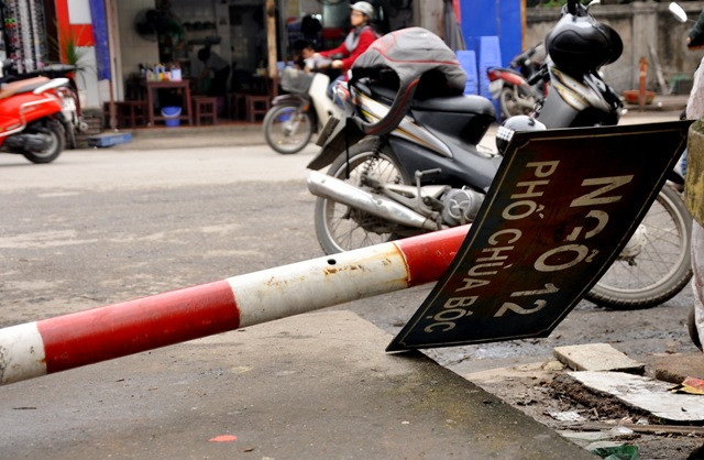 Biển chỉ đường ngõ 12 Chùa Bộc (Đống Đa, Hà Nội) nằm úp dưới đường trong nhiều tháng qua nhưng vẫn chưa được khắc phục ảnh hưởng tới việc đi lại và tìm địa chỉ của người đi đường.