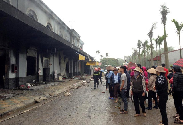 Tiểu thương và người dân xót xa đứng phía ngoài nhìn vào các gian hàng của mình.