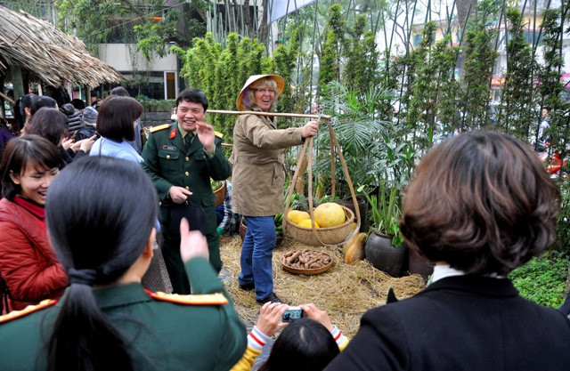 Một vị khách nước ngoài thích thú với những dụng cụ lao động của người nông dân được trưng bày tại “chợ quê”. Một vị khách nước ngoài thích thú với những dụng cụ lao động của người nông dân được trưng bày tại “chợ quê”.
