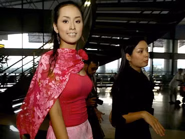 Áo hồng, váy hồng, khăn choàng hồng, Mai Phương Thúy rực rỡ và hồn nhiên giữa đám đông vây quanh ngay tại phòng làm thủ tục xuất cảnh lên đường dự thi Miss World vào tháng 9/2006.