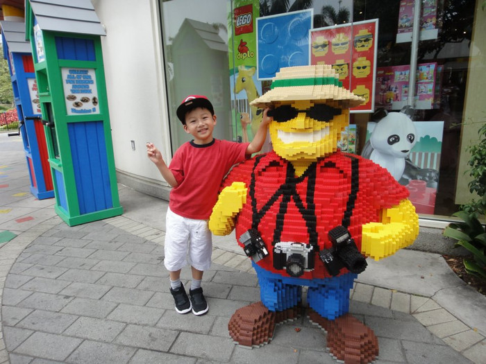 Cậu bé nhí nhảnh chụp ảnh bên những bức tượng hài hước tại Legoland. Cậu bé nhí nhảnh chụp ảnh bên những bức tượng hài hước tại Legoland.