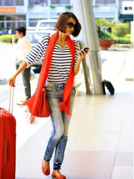 Thanh Hằng luôn ăn mặc rất đẹp và phù hợp với hoàn cảnh. Áo kẻ free size, quần jean đơn giản nhưng điểm nhấn nổi bật của trang phục đó là màu cam của phụ kiện: khăn quàng, giày bệt và cả chiếc va li chị ấy mang theo nữa.