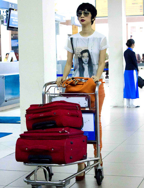 Diện áo thun trắng, quần jeans cam và mang theo những chiếc valy hành lý màu đỏ, nữ giám khảo nổi bật tại sân bay. Diện áo thun trắng, quần jeans cam và mang theo những chiếc valy hành lý màu đỏ, nữ giám khảo nổi bật tại sân bay.