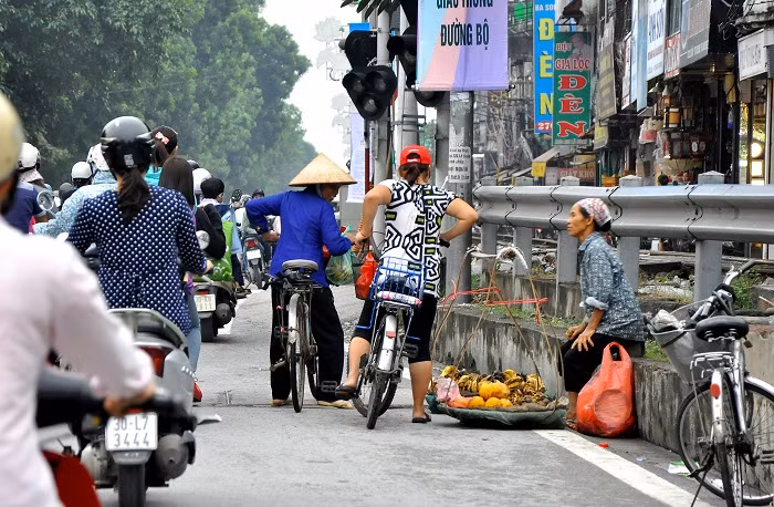 Bơm xe và đi thẳng về hướng đường Xã Đàn (ảnh: người phụ nữ hỏi giá hoa quả trên đường Lê Duẩn).