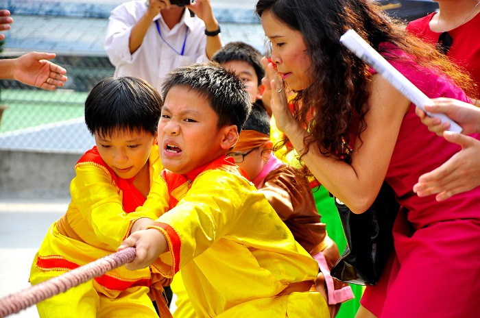 Dùng hết sức để chơi trò kéo co trong sự hò reo, cổ vũ của bạn bè và cha mẹ.