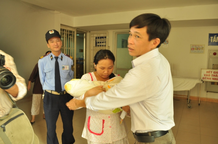 Anh Chiều đưa cháu bé cho chị Thơm bế để chuẩn bị xe