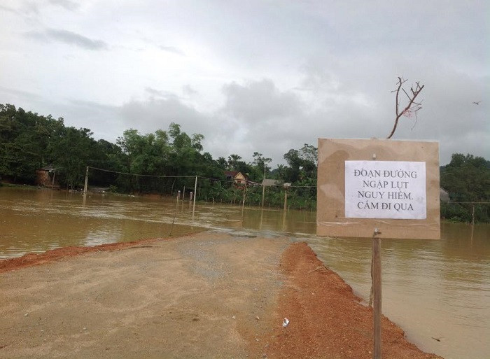 Đường vượt lũ đã bị ngập và được cảnh báo nguy hiểm (Ảnh: Lê Quốc Châu)