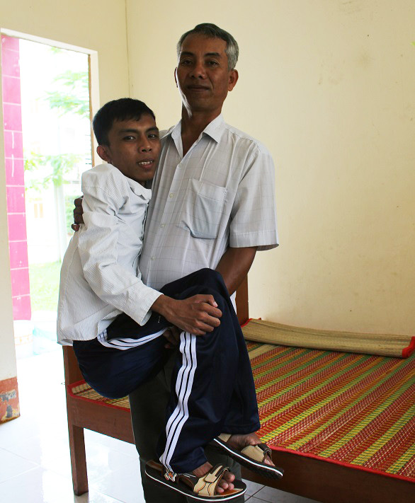 Cha bồng bế Chau Giàu trong căn phòng tại Ký túc xá (Ảnh: Huỳnh Cam) Cha bồng bế Chau Giàu trong căn phòng tại Ký túc xá (Ảnh: Huỳnh Cam)