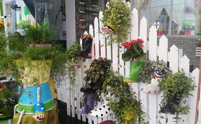 “Thổi hồn” vào những chiếc dép, đôi ủng… đã hỏng để biến nó thành những giàn hoa nhiều màu sắc.