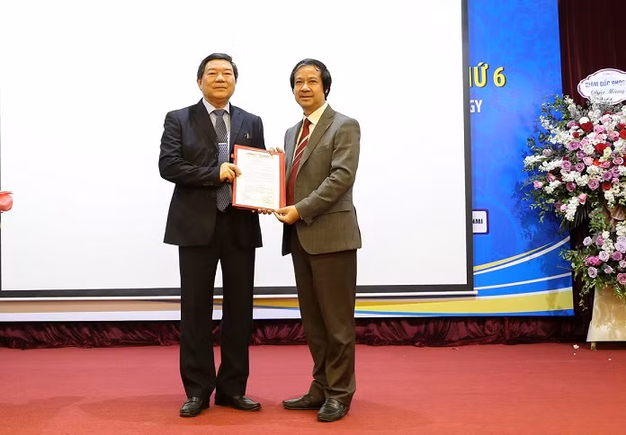 Giám đốc Đại học Quốc gia Hà Nội Nguyễn Kim Sơn (phải) trao quyết định bổ nhiệm lại cho Giám đốc Nguyễn Quốc Anh.