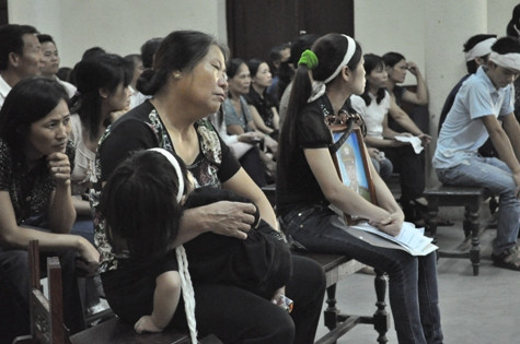 Gia đình các nạn nhân mang di ảnh nạn nhân đến tòa