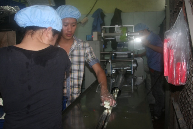 Xếp kem vào dây chuyền, kem được bọc bởi lớp nilon giữ lạnh, mang thương hiệu công ty Xếp kem vào dây chuyền, kem được bọc bởi lớp nilon giữ lạnh, mang thương hiệu công ty