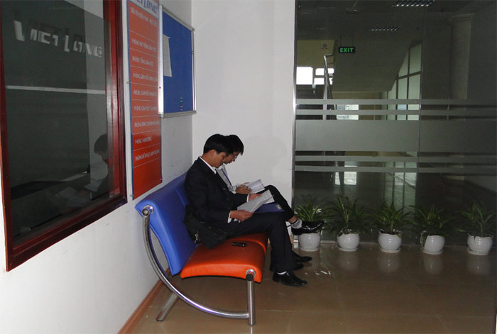 Một số khác cố gắng tìm chút ánh sáng tự nhiên để đọc tài liệu tại hành lang phía bên ngoài phòng làm việc.