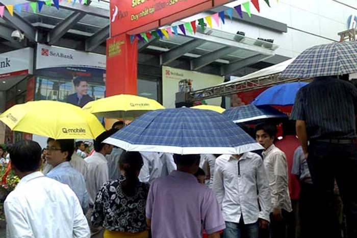 Dù mưa nặng hạt bất chợt trút xuống, nhiều người vẫn che ô kiên nhẫn chờ đợi. (Ảnh: VNE) Dù mưa nặng hạt bất chợt trút xuống, nhiều người vẫn che ô kiên nhẫn chờ đợi. (Ảnh: VNE)