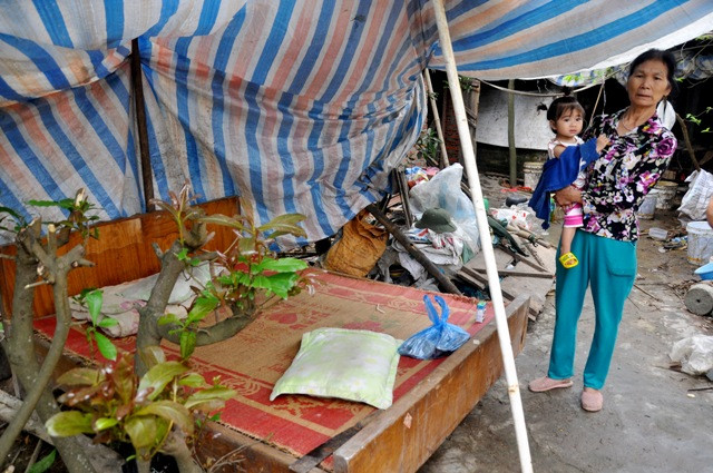 Có nhà nhưng gia đình bà Vĩ phải kê giường ngoài vườn và căng bạt che nắng, che mưa để ngủ….