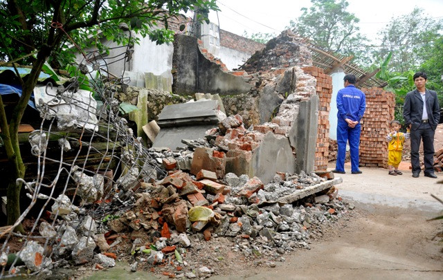 Chiếc cổng và tường rào nhà bà Phùng Thị Tý đối diện với giếng khoan bị đổ sụp. Cũng theo người dân nơi đây, tại khu vực đất nền gần giếng khoan nhà anh Cương bị sụt sâu xuống khoảng 60cm so với mặt đất nền trước đó.